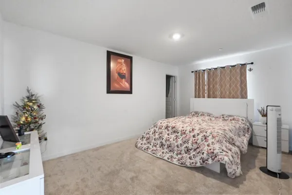 a bedroom with a bed and a potted plant