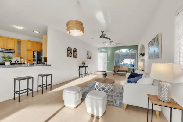 a living room with furniture and a large mirror with wooden floor