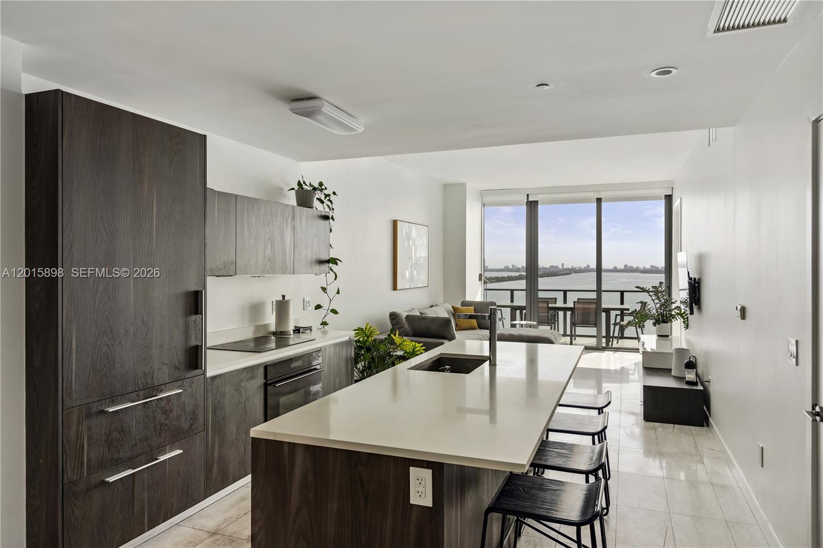 480 Northeast 31st Street, Unit 1802 Miami, FL 33137 - Photo 2 of 50 a large kitchen with a table chairs and flat screen tv