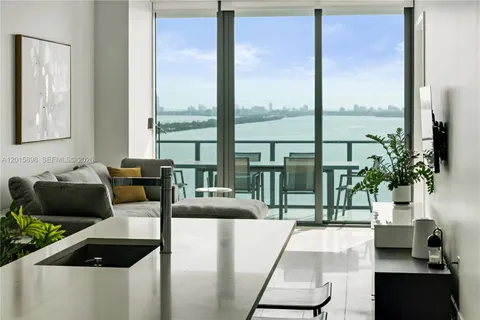 a living room with furniture and a floor to ceiling window