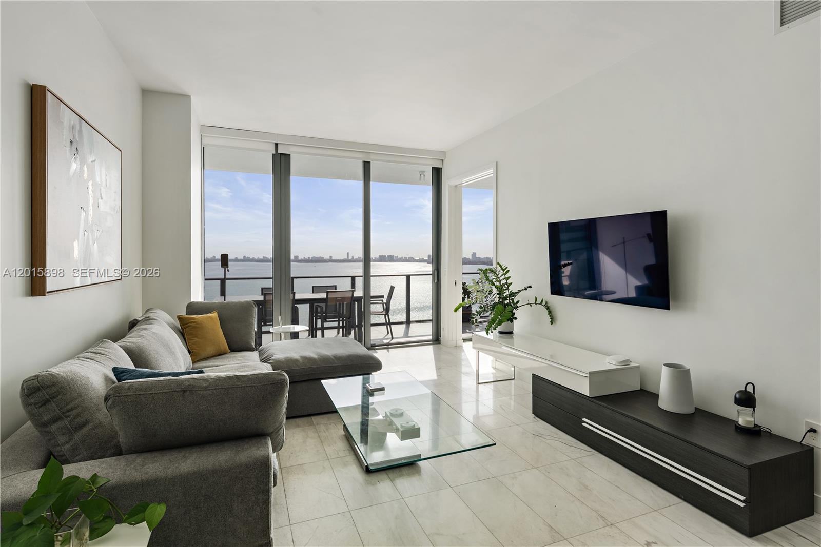 480 Northeast 31st Street, Unit 1802 Miami, FL 33137 - Photo 4 of 50 a living room with furniture and a flat screen tv