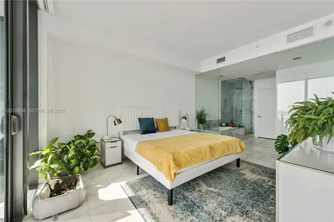 a bed room with a bed and a potted plant