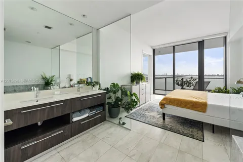 a spacious bathroom with a double vanity and a large mirror next to a large window