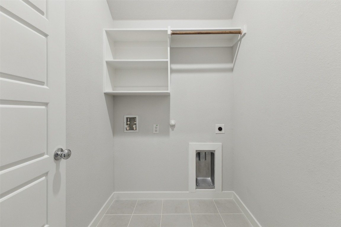 200 Hidalgo Lane Elgin, TX 78621 - Photo 17 of 25 Washroom with electric dryer hookup, light tile patterned floors, gas dryer hookup, hookup for a washing machine, and baseboards