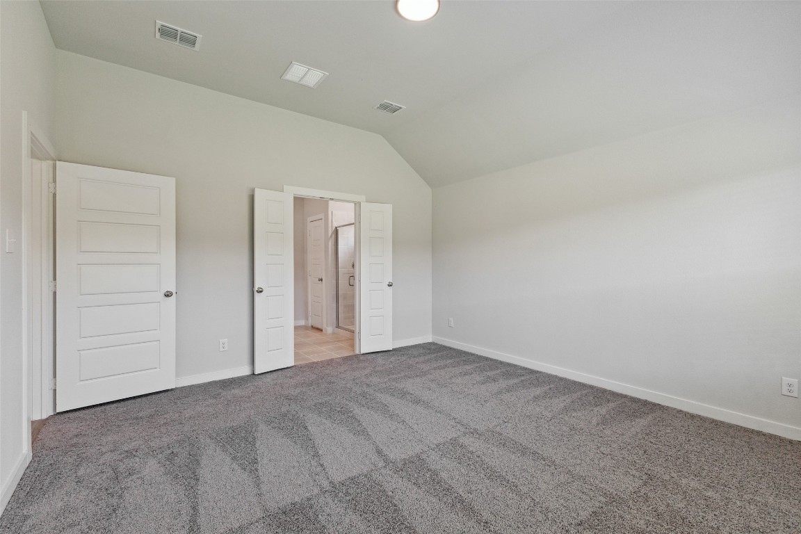 200 Hidalgo Lane Elgin, TX 78621 - Photo 10 of 25 Unfurnished bedroom with light colored carpet, vaulted ceiling, and baseboards