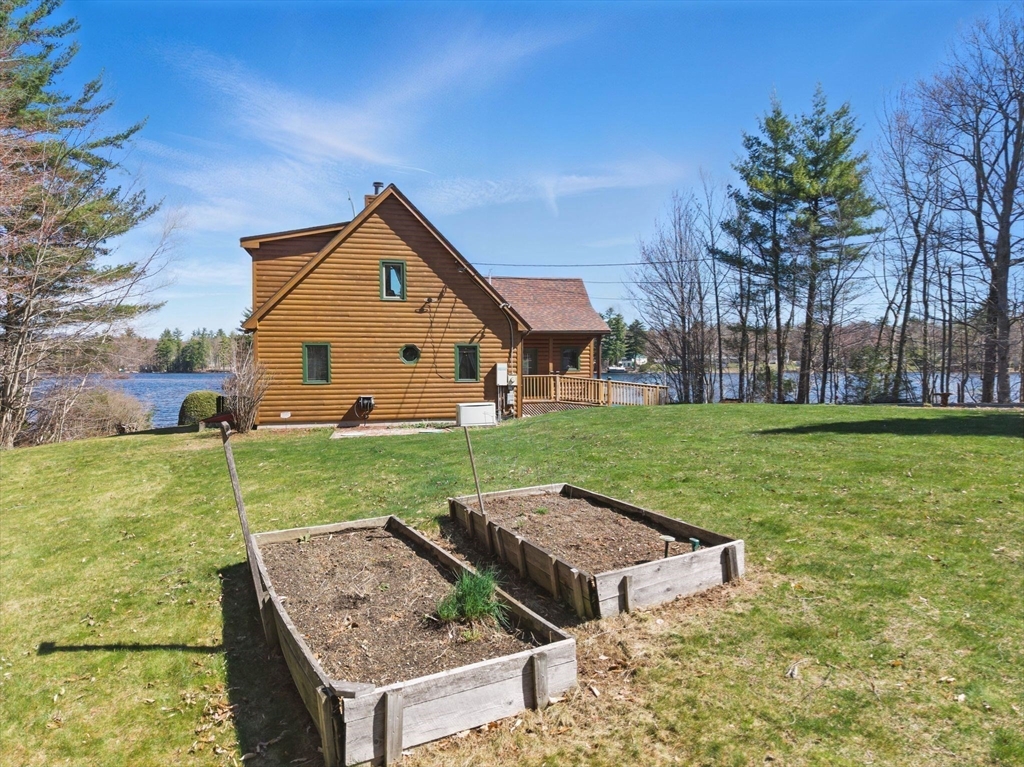 44 Auclair Road Middleton, NH 03887 - Photo 4 of 7 a view of a house with big yard and a garden