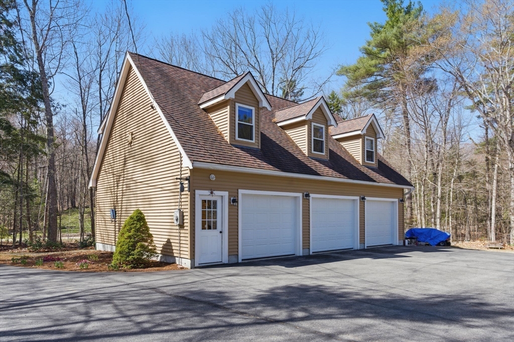 44 Auclair Road Middleton, NH 03887 - Photo 5 of 7 a view of a house with a yard and garage