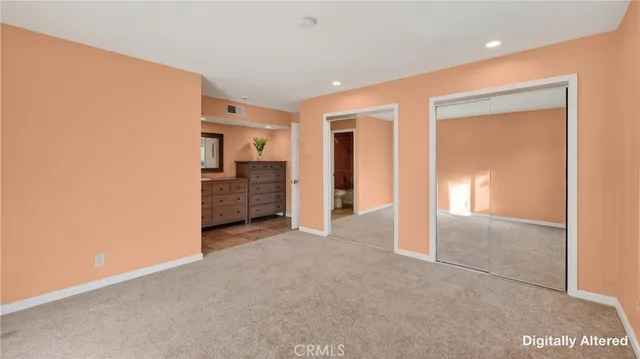 an empty room with windows and cabinet