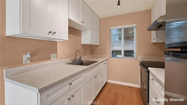 a kitchen with granite countertop a sink a stove and cabinets