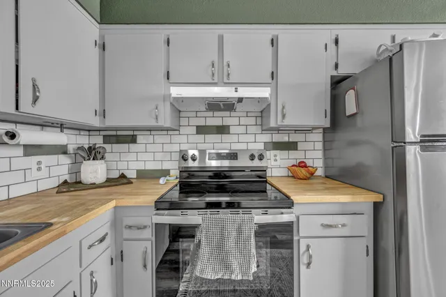 a kitchen with stainless steel appliances a stove a sink and cabinets