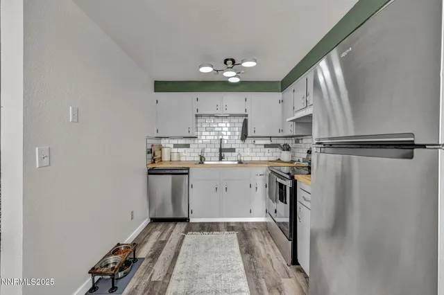 a kitchen with a refrigerator sink and wooden floor
