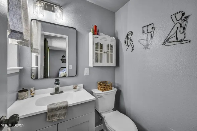 a bathroom with a sink mirror and toilet