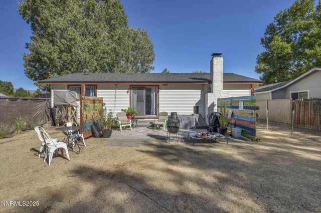 a view of backyard with outdoor seating and plants
