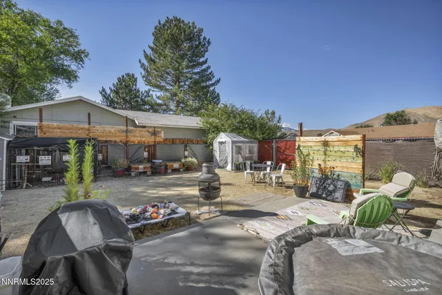 a view of a patio with table and chairs couches under an umbrella with large trees