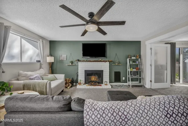 a living room with furniture a flat screen tv and a fireplace