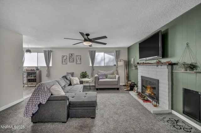 a living room with furniture a flat screen tv and a fireplace