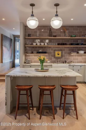 a kitchen with a sink a table and chairs in it