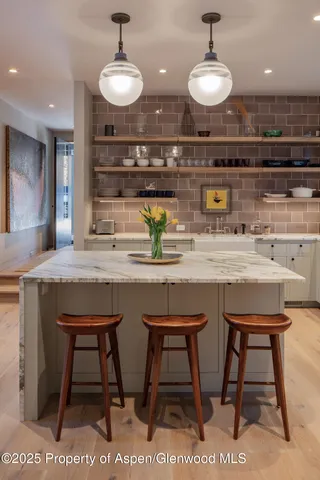 a kitchen with a sink a table and chairs in it