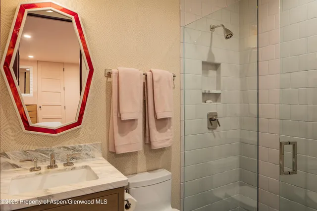 a bathroom with a sink a toilet and a mirror