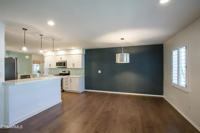 a kitchen with kitchen island white cabinets and stainless steel appliances