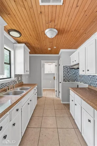 a large white kitchen with a sink and cabinets
