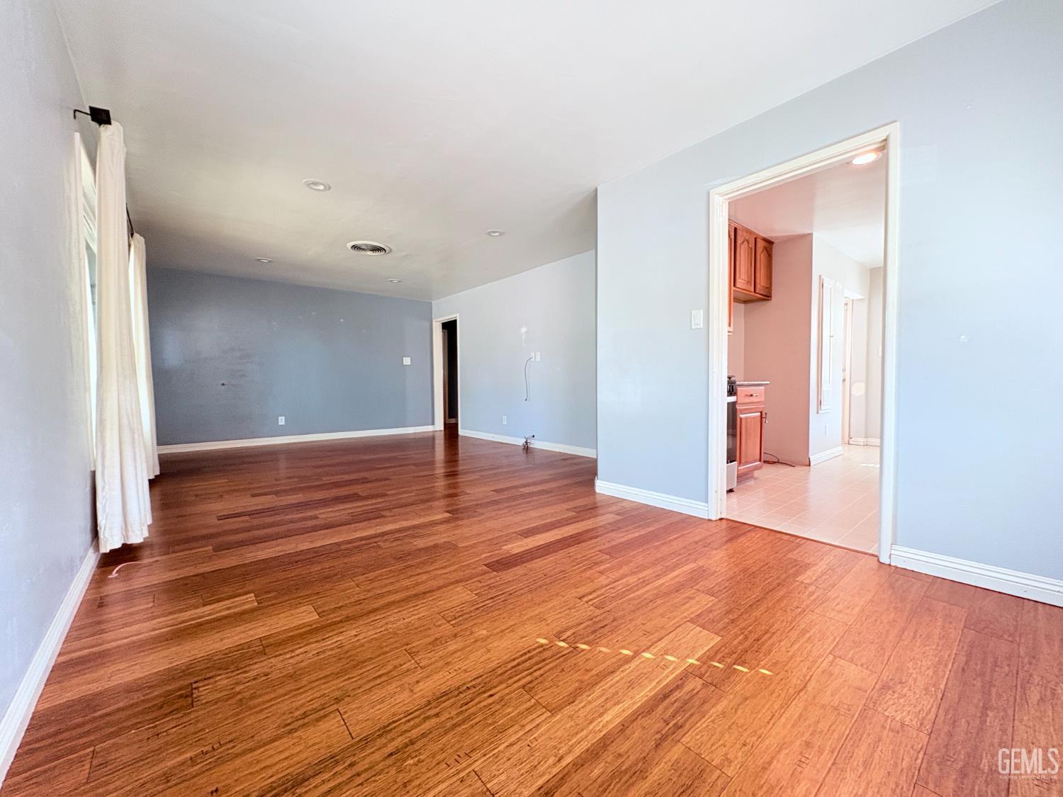 Undisclosed Address Bakersfield, CA 93301 - Photo 2 of 11 a view of an empty room with wooden floor