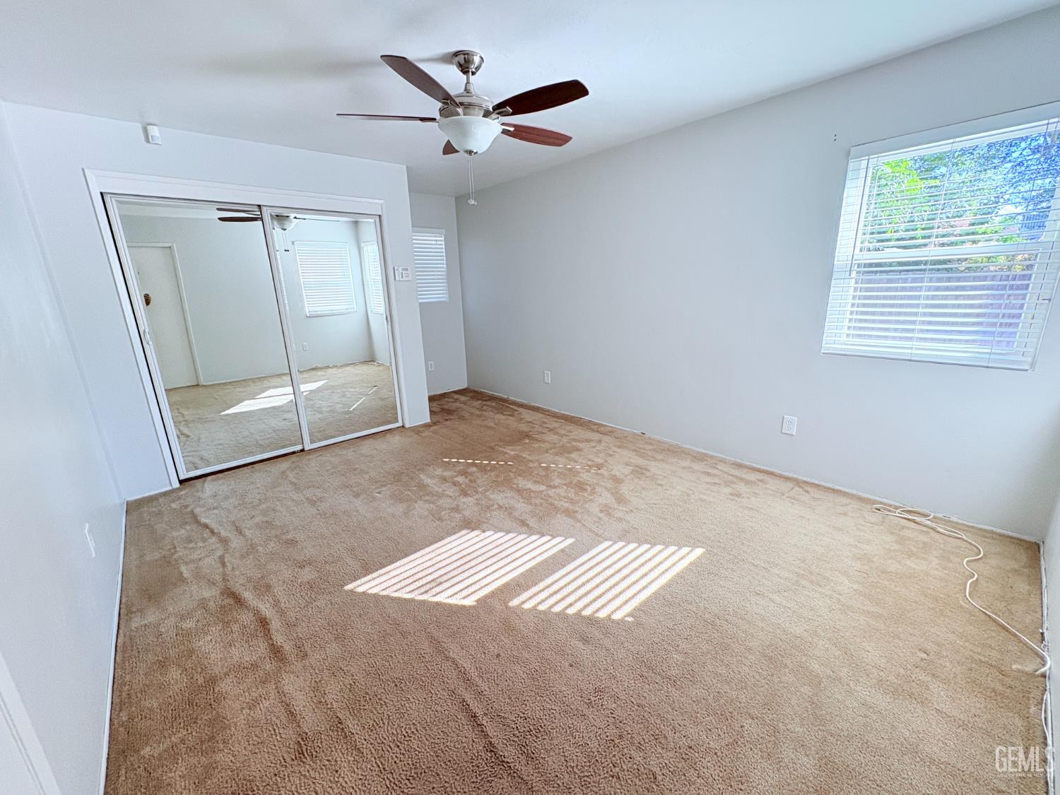 Undisclosed Address Bakersfield, CA 93301 - Photo 8 of 11 an empty room with windows and fan