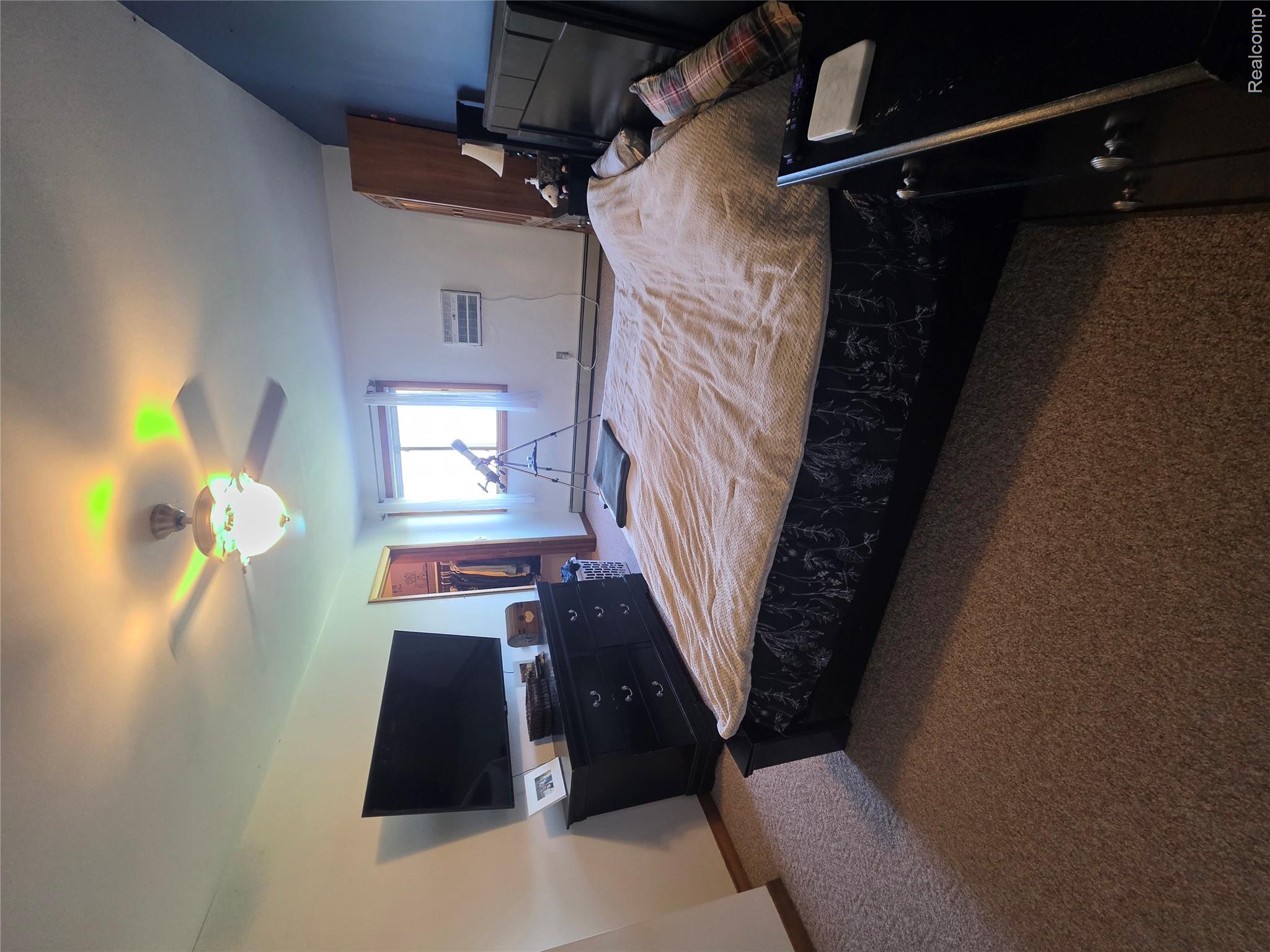 5847 F Road Bark River, MI 49807 - Photo 7 of 25 Bedroom featuring dark carpet, ceiling fan, a walk in closet, and a baseboard radiator