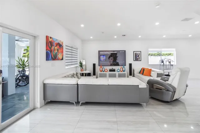 a kitchen with stainless steel appliances a sink a stove a refrigerator cabinets and a window