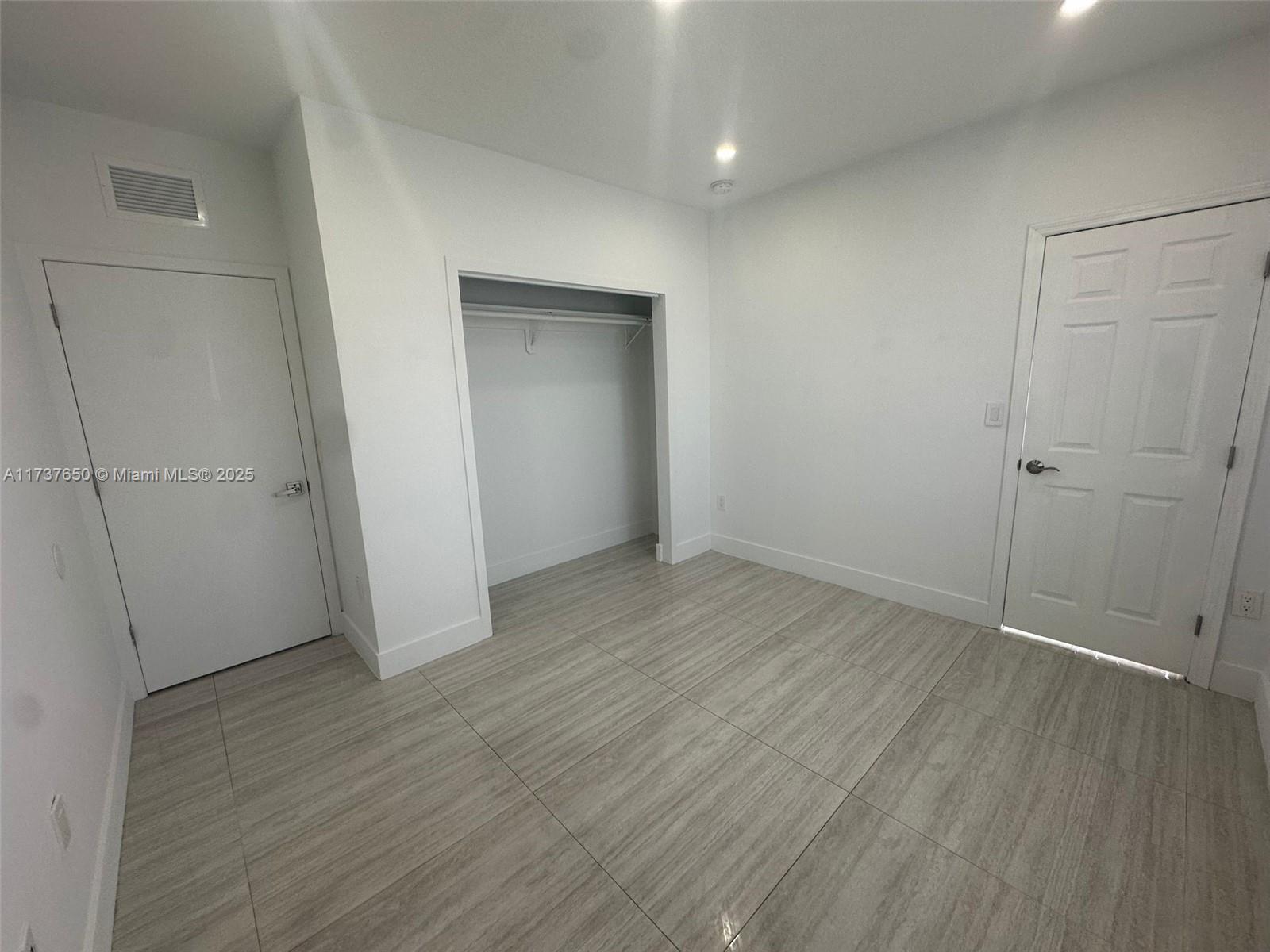 10290 Southwest 7th Terrace Sweetwater, FL 33174 - Photo 54 of 58 an empty room with wooden floor and closet