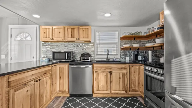 a kitchen with stainless steel appliances granite countertop a stove and a sink