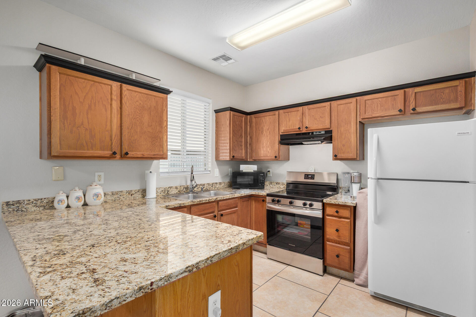 2300 East Magma Road, Unit 28 San Tan Valley, AZ 85143 - Photo 2 of 23 a kitchen with granite countertop a refrigerator stove and sink