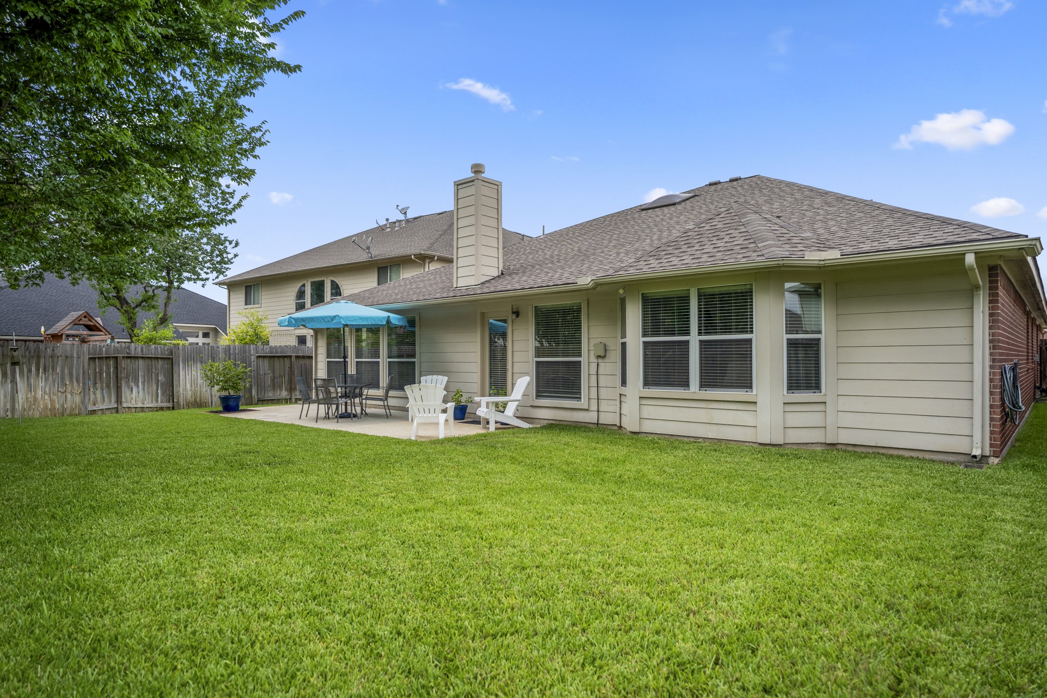 3411 Utah Beach Court Spring, TX 77388 - Photo 38 of 50 Looking back at the rear of the home, the backyard shows how the patio and lawn work together for outdoor living. The back door connects inside near the breakfast room and family room, while the patio sits just off the main gathering spaces with room to relax, dine, and enjoy the yard.