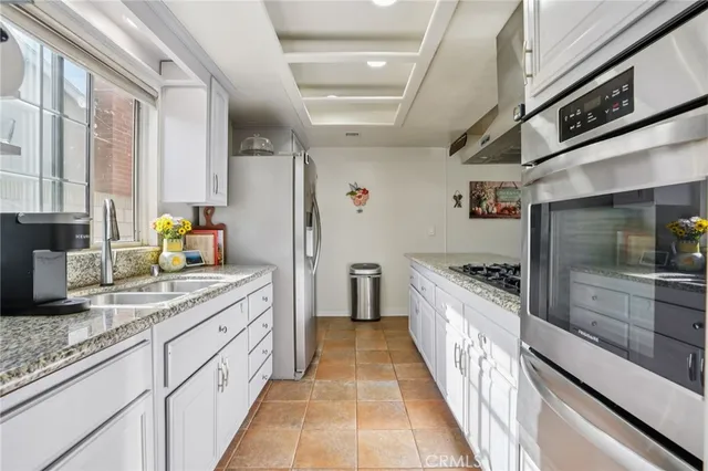 a large kitchen with stainless steel appliances granite countertop a lot of counter space