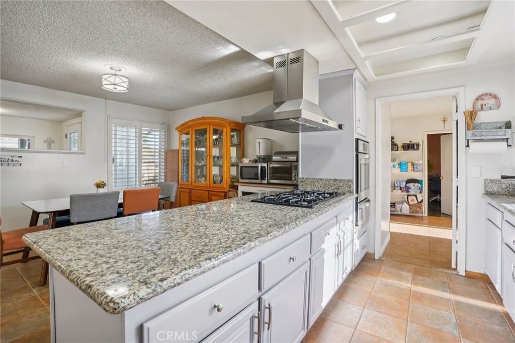 215 South Rock River Road Diamond Bar, CA 91765 - Photo 12 of 32 a kitchen with stainless steel appliances granite countertop a sink and a wooden floor