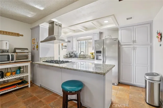 a kitchen with stainless steel appliances granite countertop a refrigerator a stove and a sink