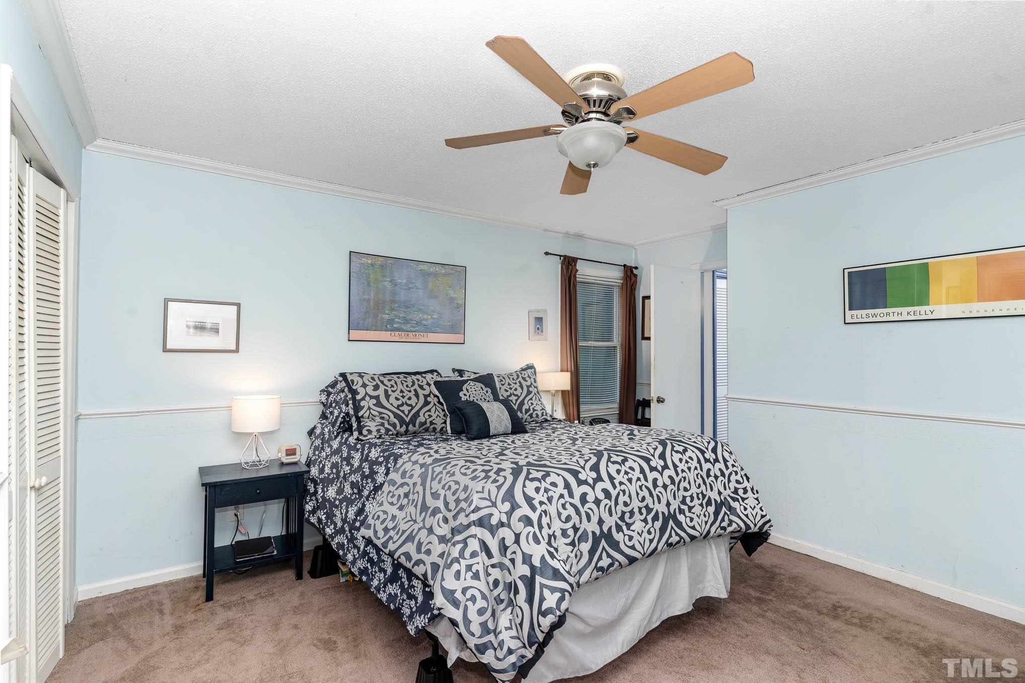3233 Banks Road Raleigh, NC 27603 - Photo 13 of 27 a bedroom with a large bed and a chandelier