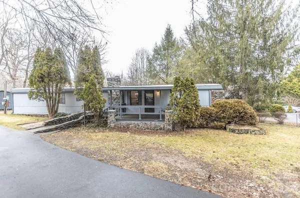 a view of house with yard and sitting area