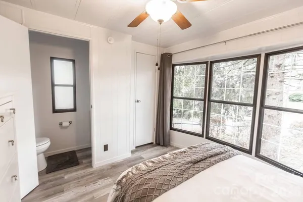 a bedroom with a bed and a large window with outer view