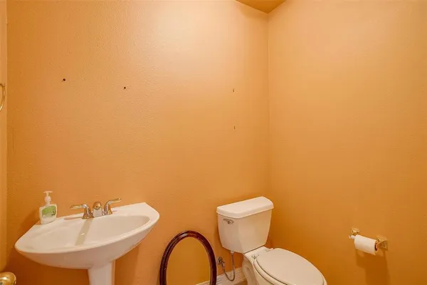 a bathroom with a toilet a sink and mirror