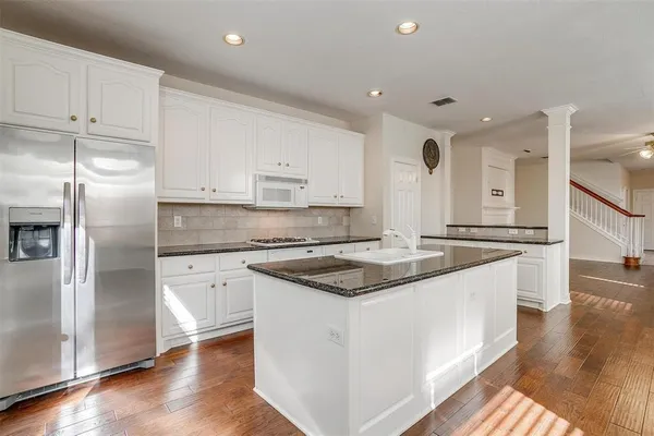 a kitchen with stainless steel appliances granite countertop a sink a refrigerator and a stove