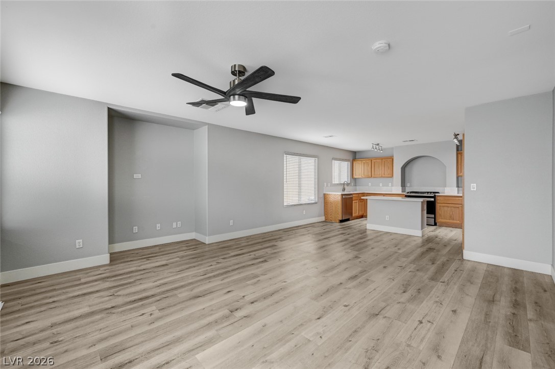 7259 Cestrum Road Las Vegas, NV 89113 - Photo 8 of 35 An open-concept living space integrates a well-appointed kitchen with warm wooden cabinetry.