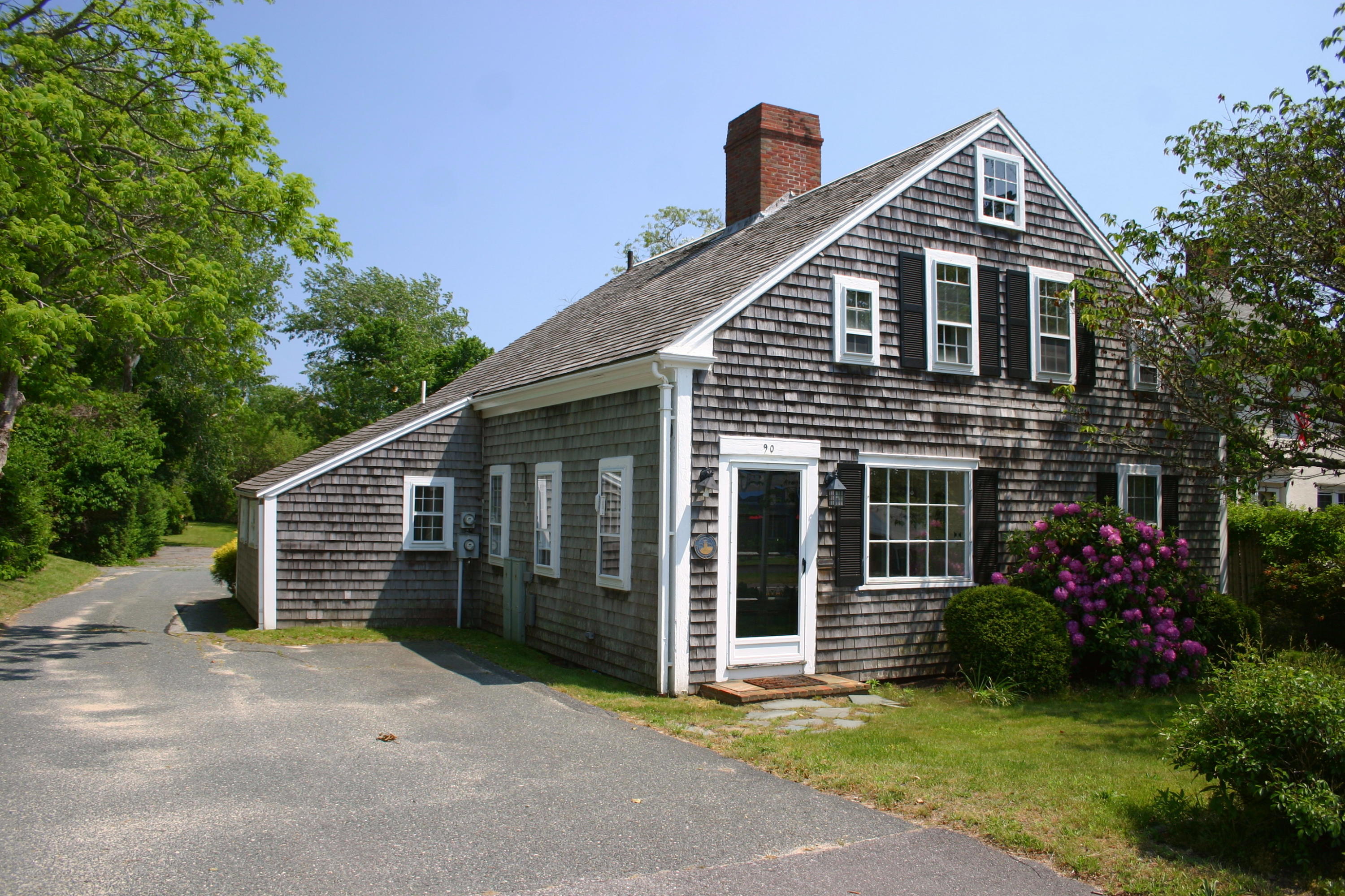 a front view of a house with a garden and plants