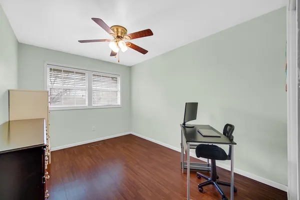 a view of a workspace with wooden floor and a window