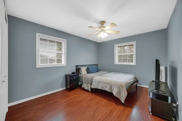 a bedroom with a bed ceiling fan and a window
