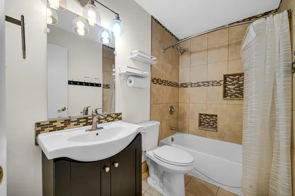 a bathroom with a sink a toilet a mirror a vanity and shower
