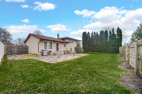 a view of a house with backyard and sitting area