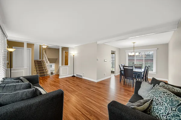 a living room with furniture wooden floor and dining table