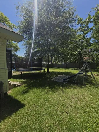 a view of a house with backyard and a tree