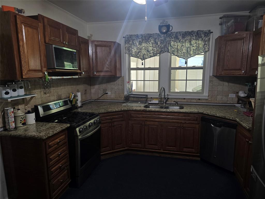 206 Summit Street Minden, LA 71055 - Photo 10 of 23 a kitchen with granite countertop a sink wooden cabinets and a stove top oven